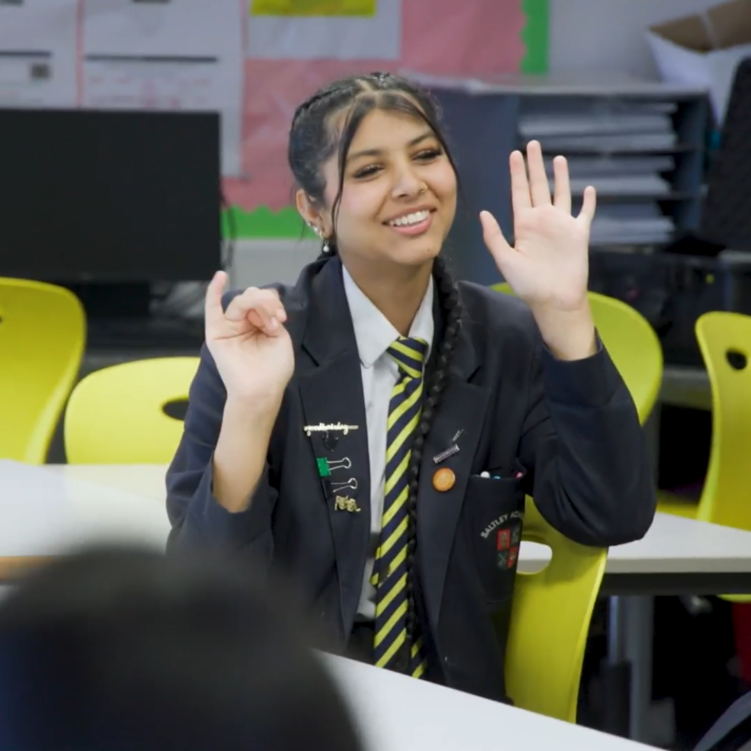 girl in class raising her hands